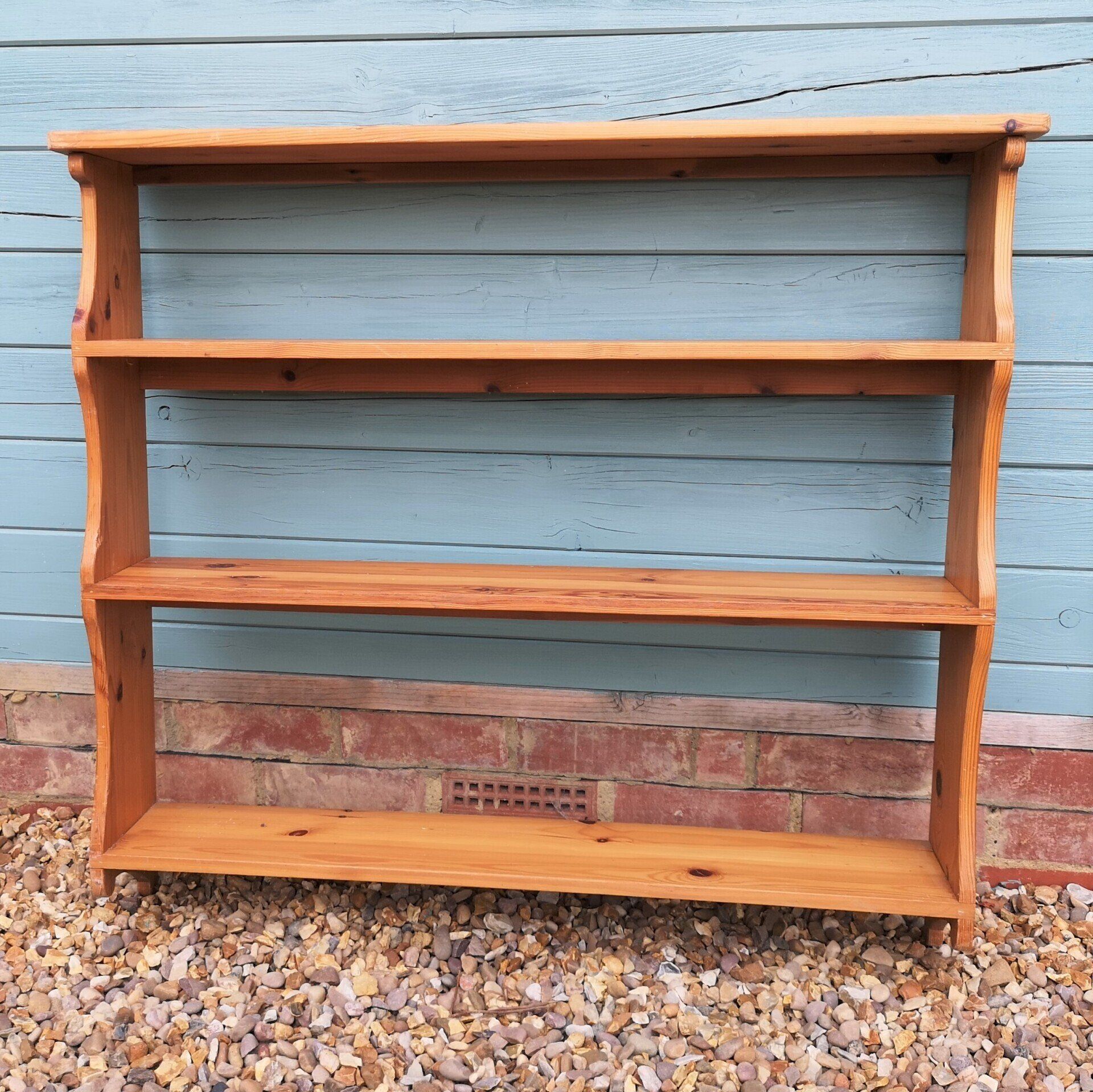 A wooden shelf is sitting in front of a blue wall