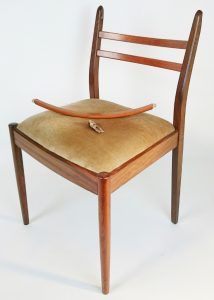 A wooden chair with a broken cushion on it