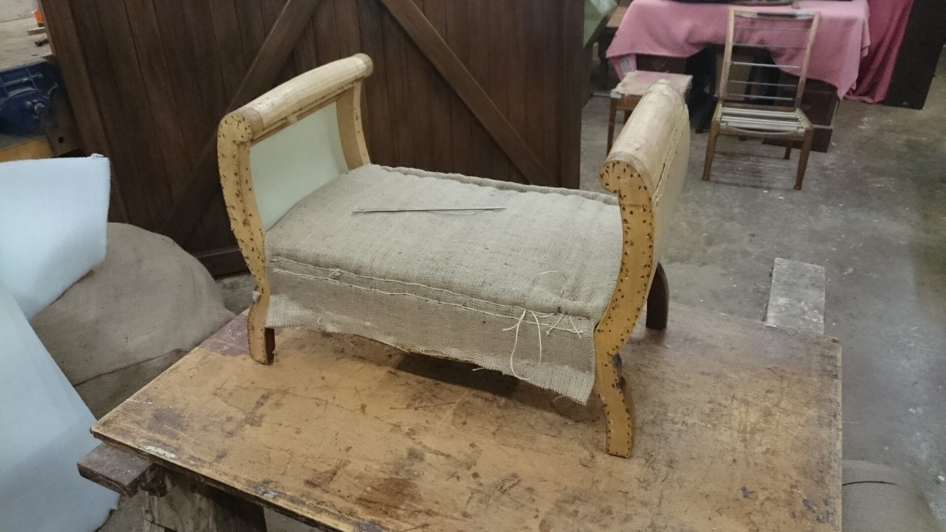 A wooden bench is sitting on top of a wooden table.