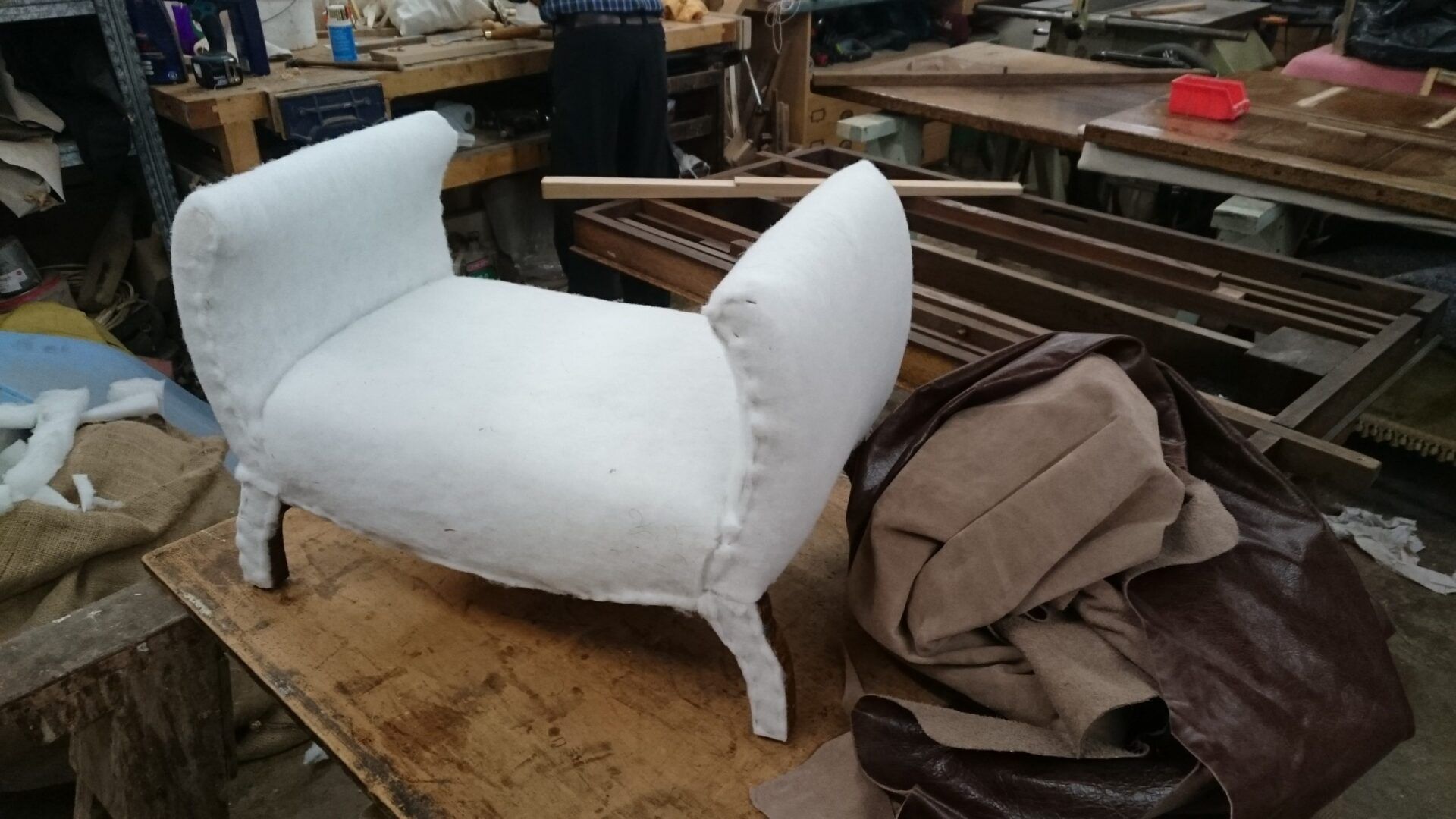 A white bench is sitting on top of a wooden table.