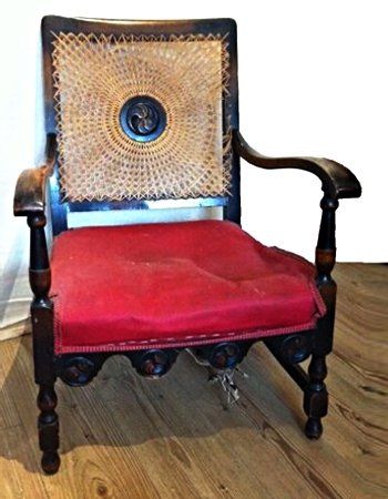 A wooden chair with a red cushion and a wicker back