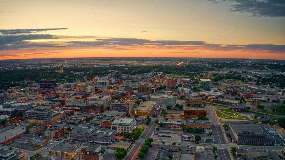 Aerial view of a city at sunset with colorful sky. 