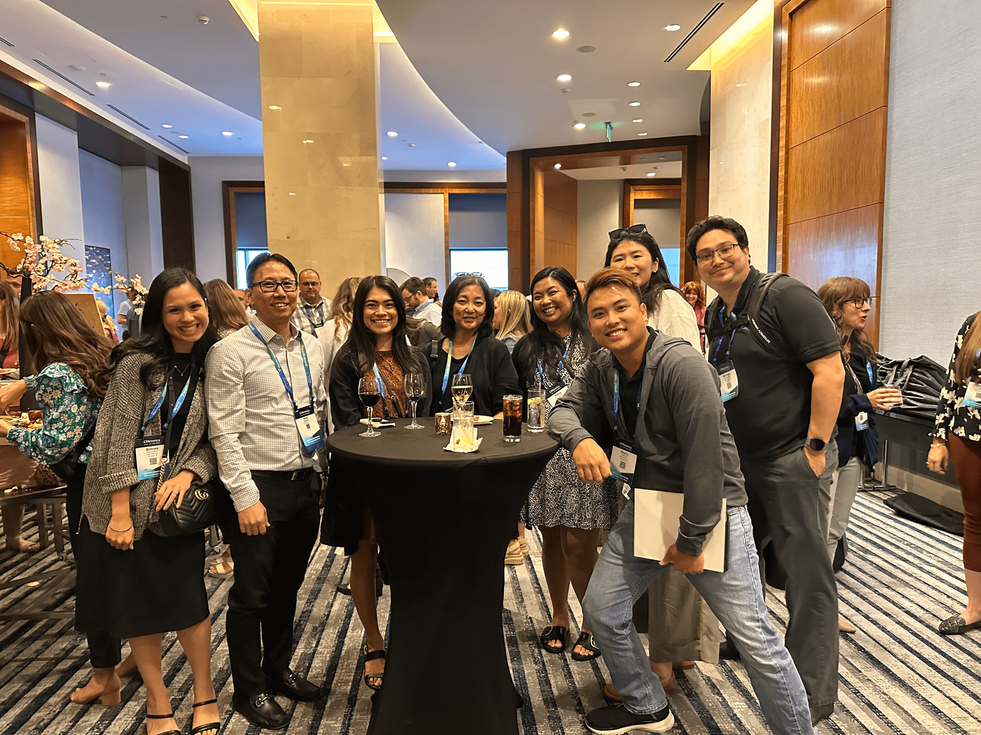 a group of experienced N&K cpas, inc accountants stand around a table in a professional business conference in a hotel event room