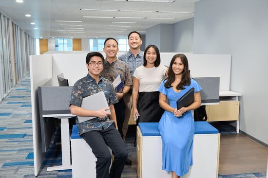 N&K accounting employees sitting together in the main office space smiling