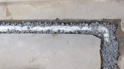 A pipe is being installed in a concrete wall.