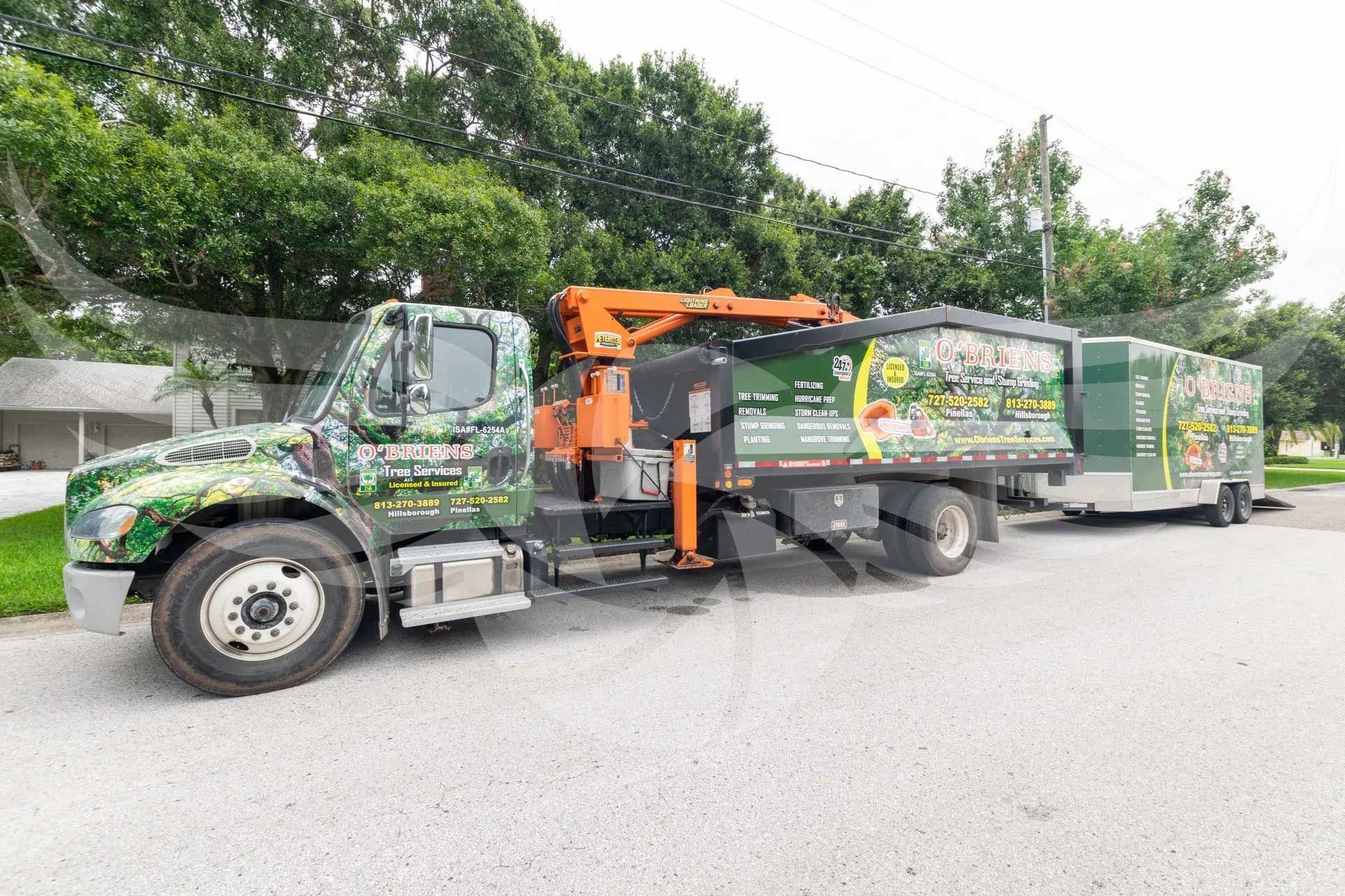 A truck with a trailer attached to it is parked in a parking lot.
