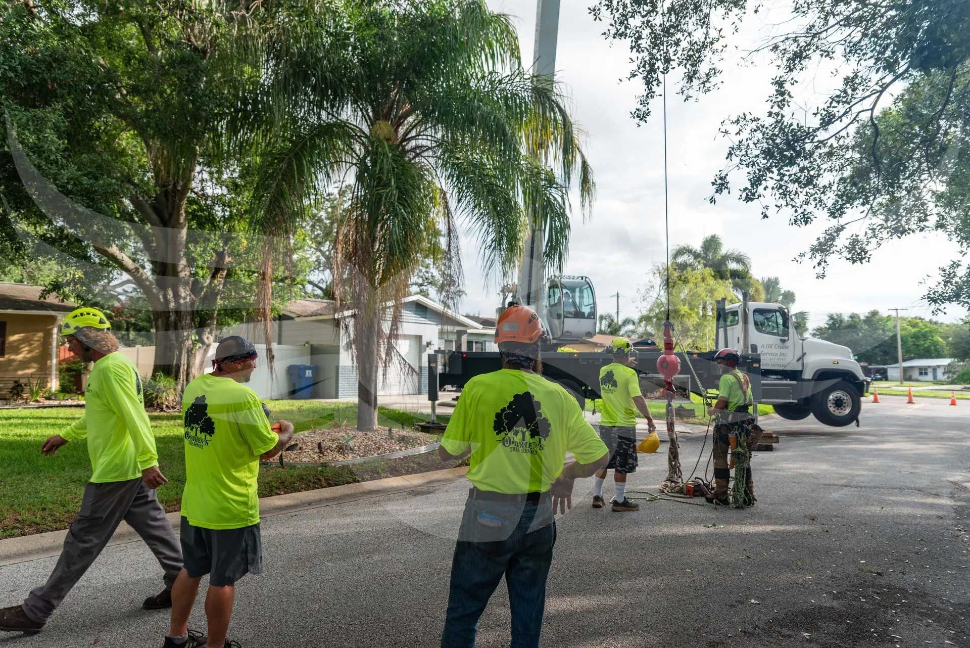 A group of men in neon green shirts are standing in front of a truck.