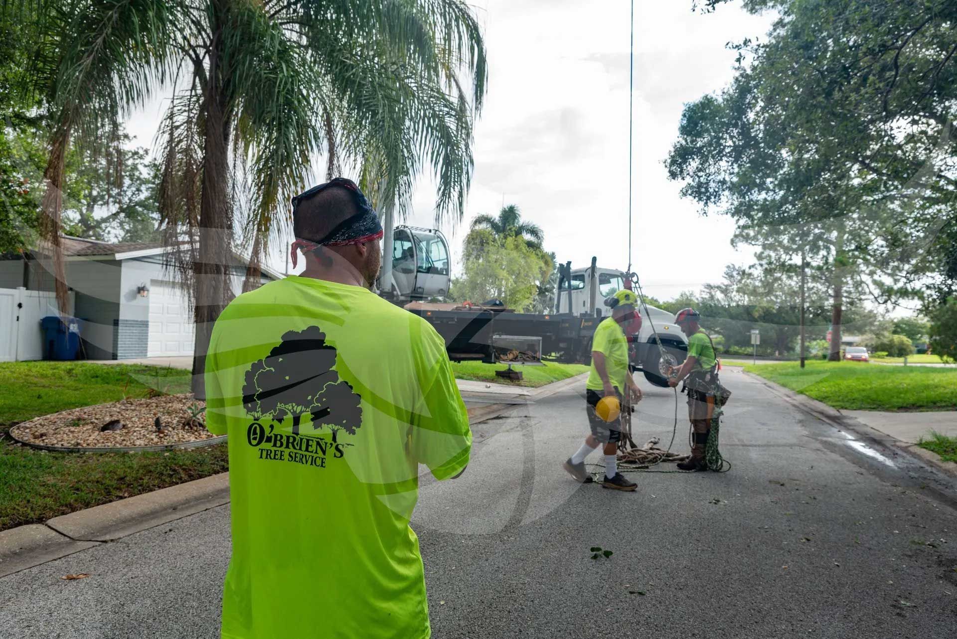 A man in a neon green shirt is standing on the side of the road.