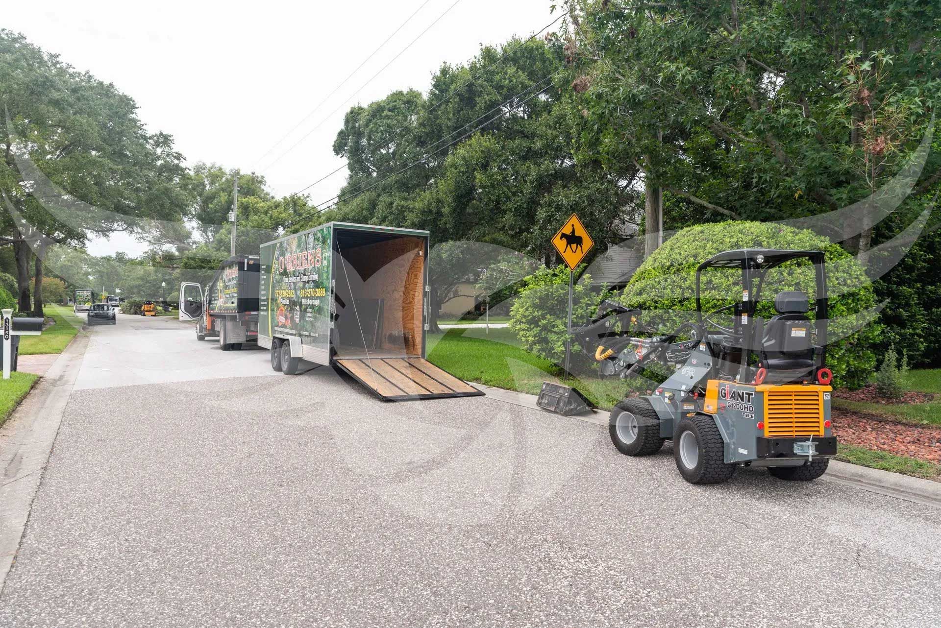 A forklift is parked on the side of the road next to a truck