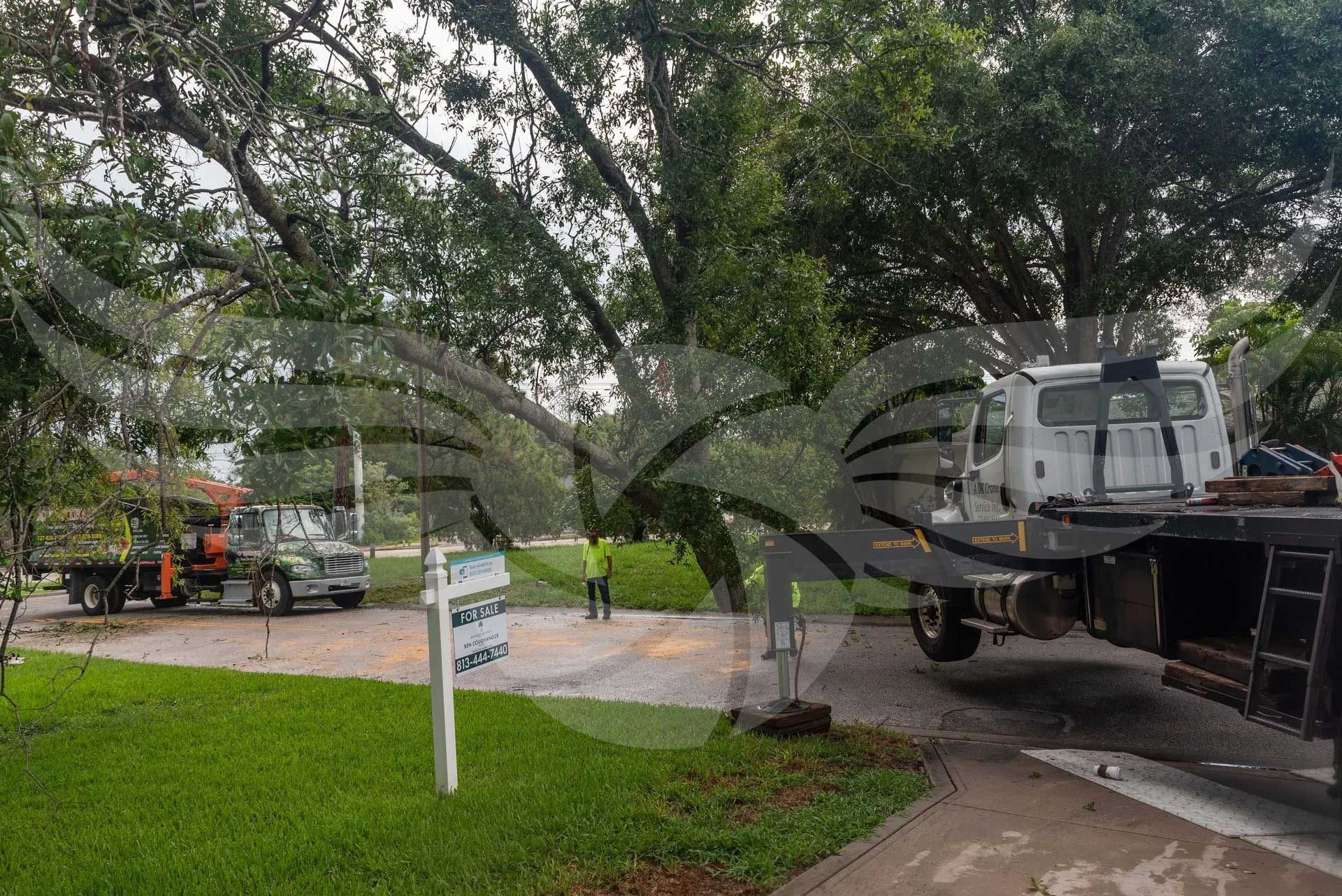 A tow truck is parked on the side of the road next to a sign.