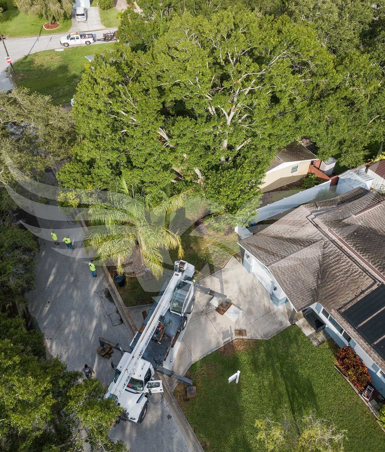 An aerial view of a house with a crane in front of it.
