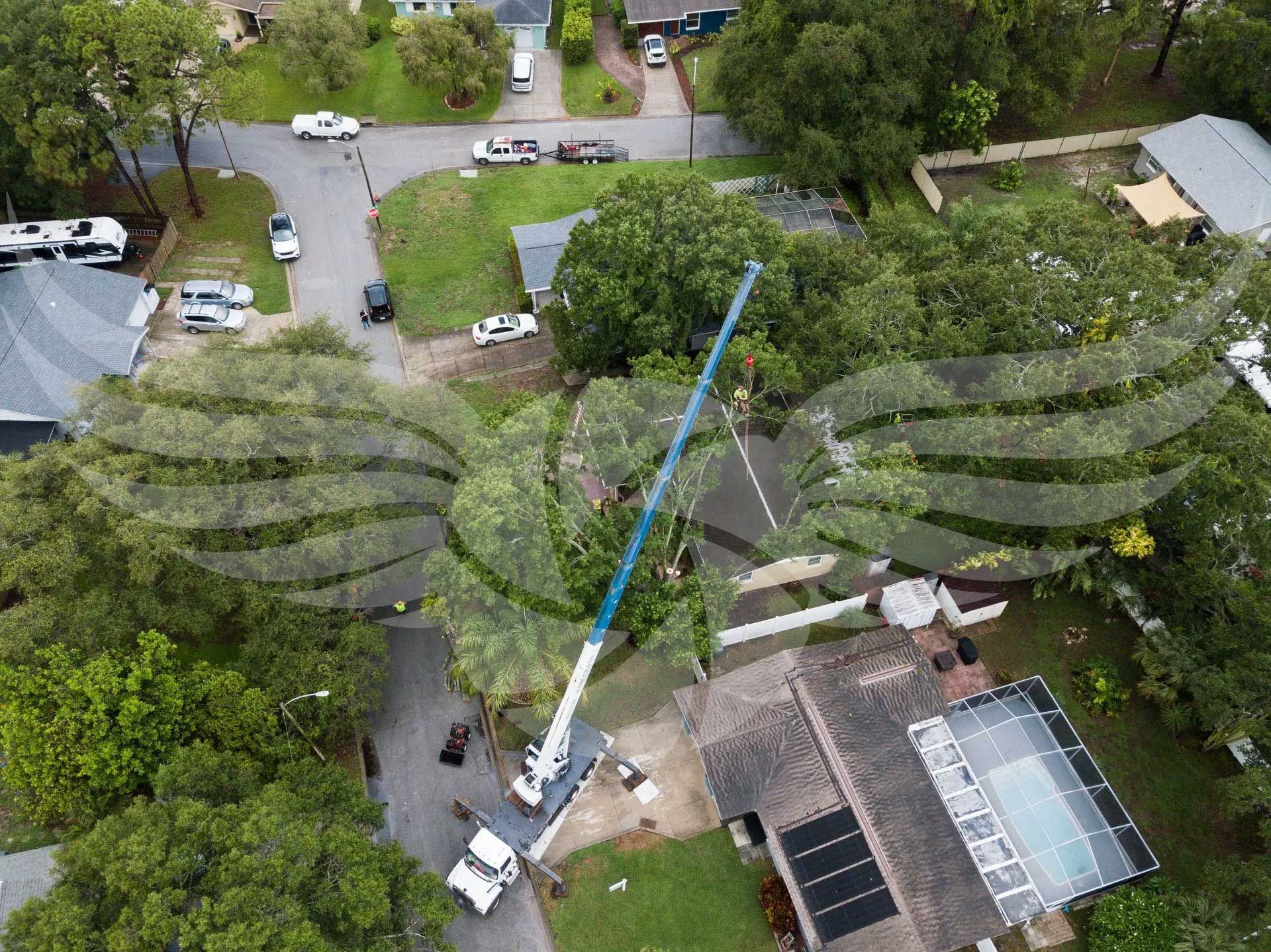 An aerial view of a house with a crane working on the roof.