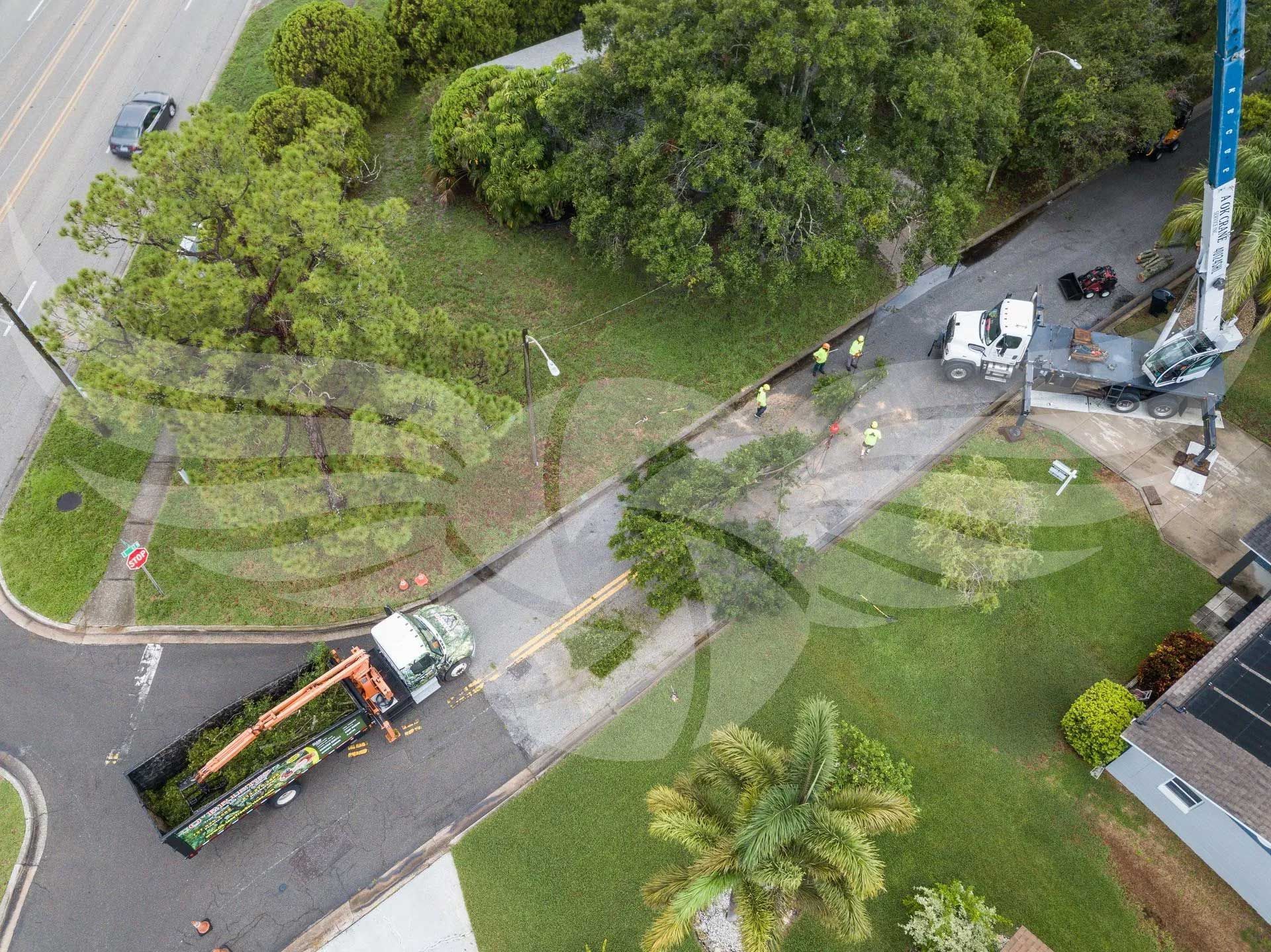 An aerial view of a truck driving down a street next to a house.