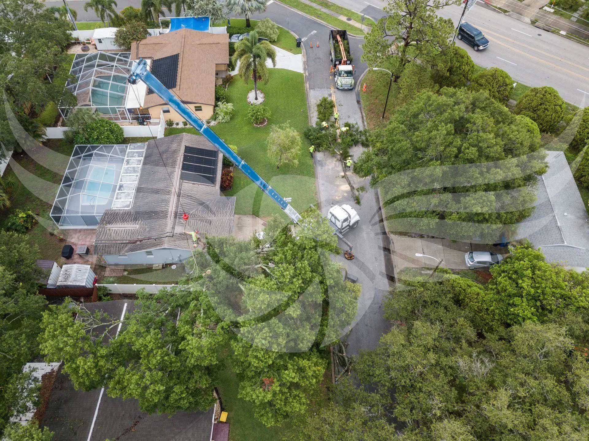 An aerial view of a house with a crane in front of it.