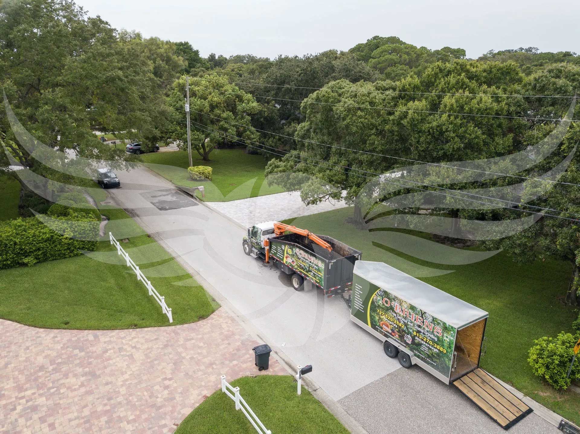 An aerial view of a truck carrying a trailer down a street.