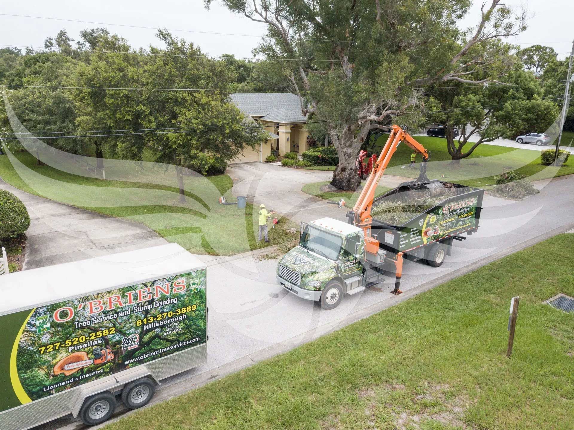 An aerial view of a dump truck driving down a road next to a house.