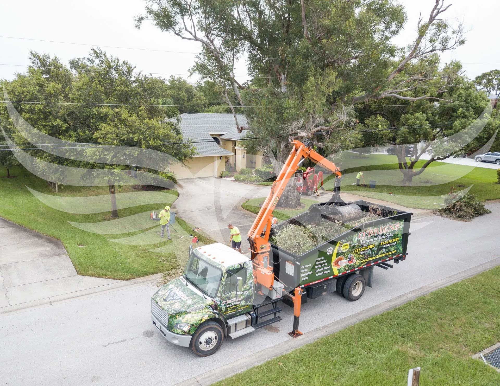 An aerial view of a tree trimming truck driving down a street.