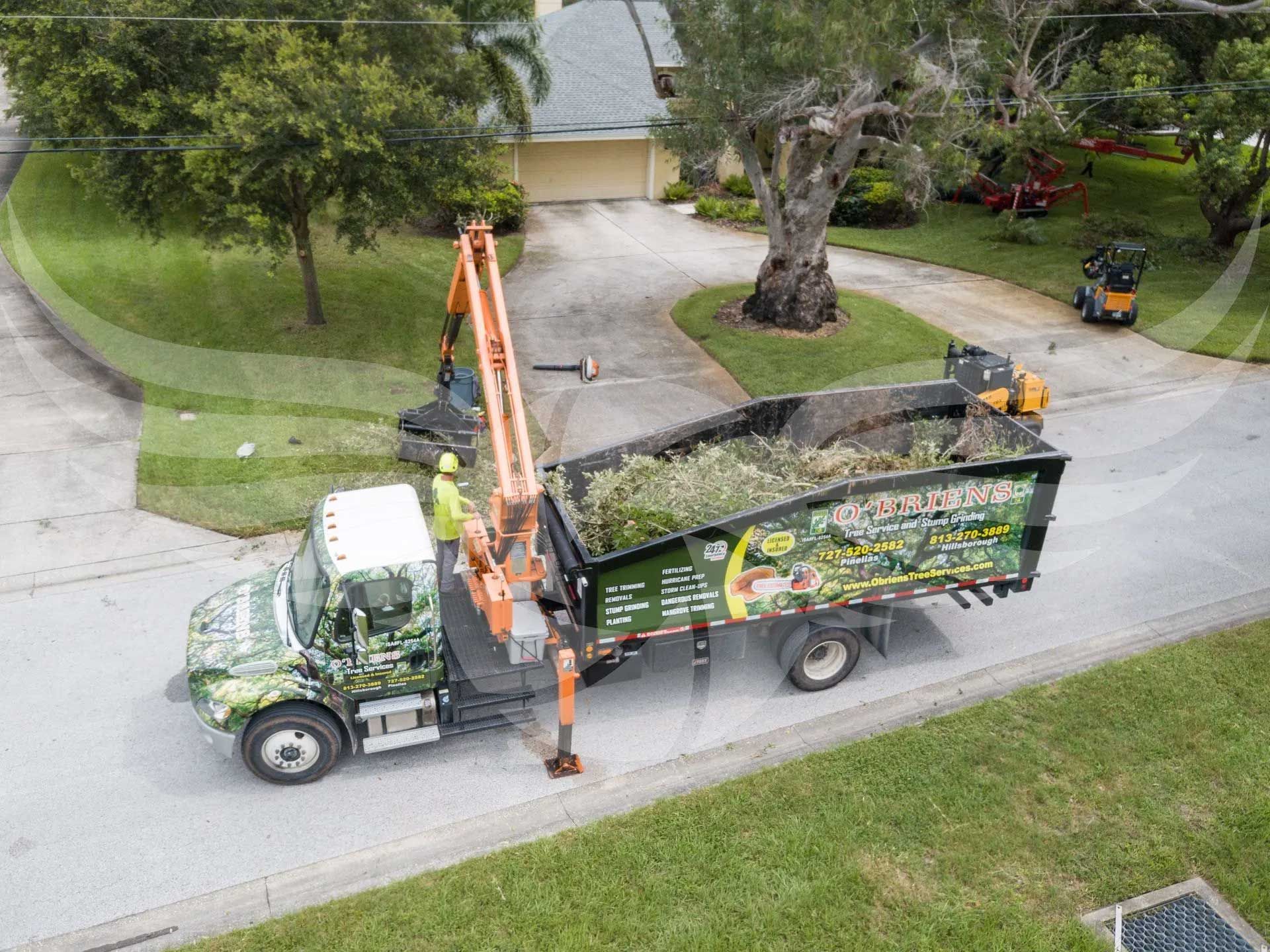 An aerial view of a dump truck driving down a street.