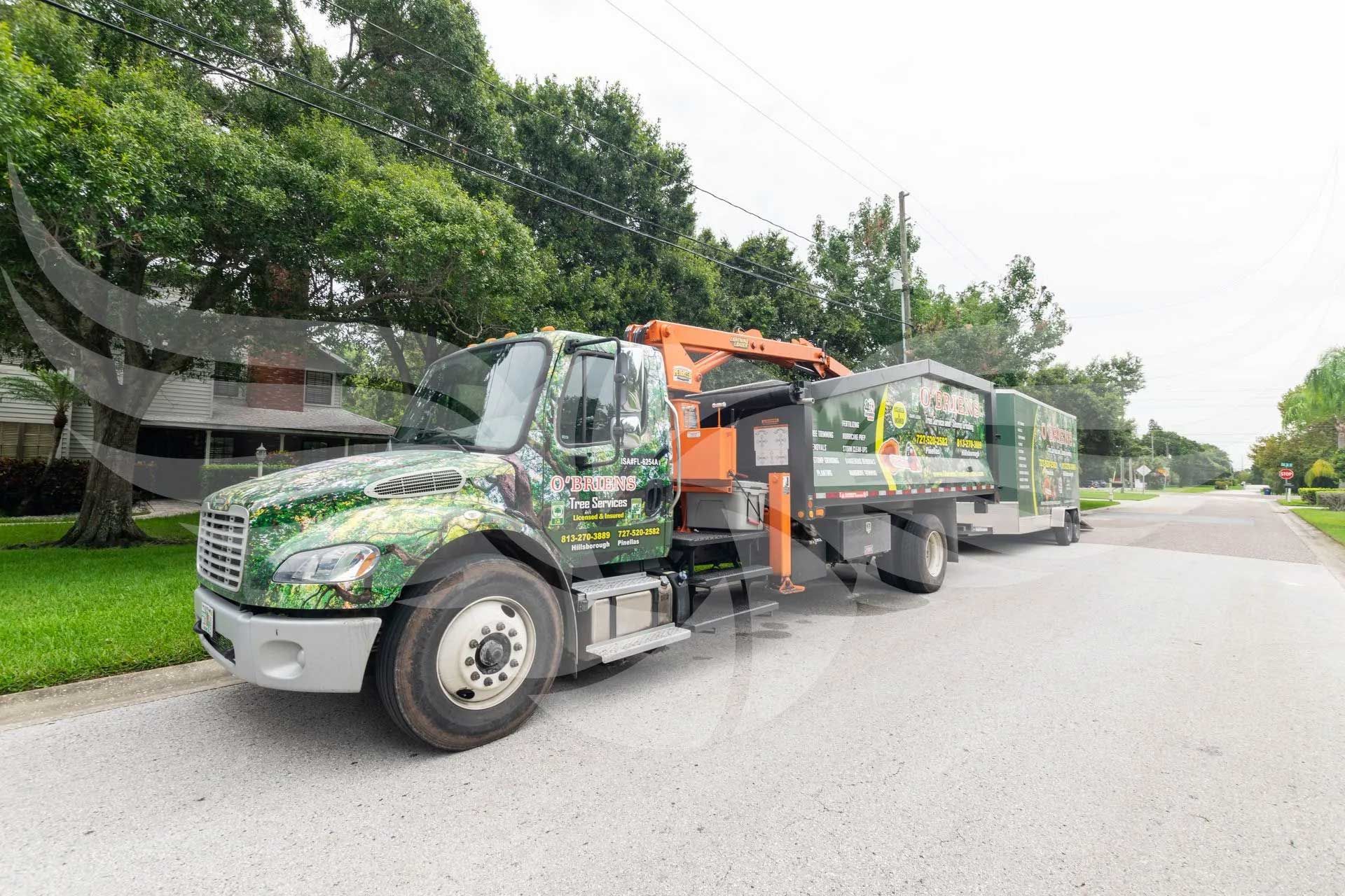 A truck with a crane on the back is parked on the side of the road.