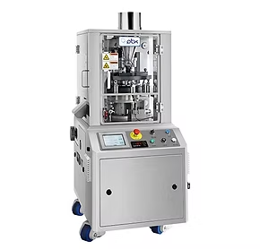 Tablet press machine with stainless steel exterior, control panel, and safety glass enclosure.