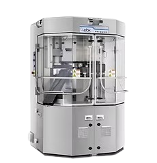 Tablet press machine with clear safety doors and metallic casing.