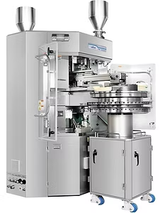 Pharmaceutical tablet press machine, stainless steel construction with hoppers, producing tablets.