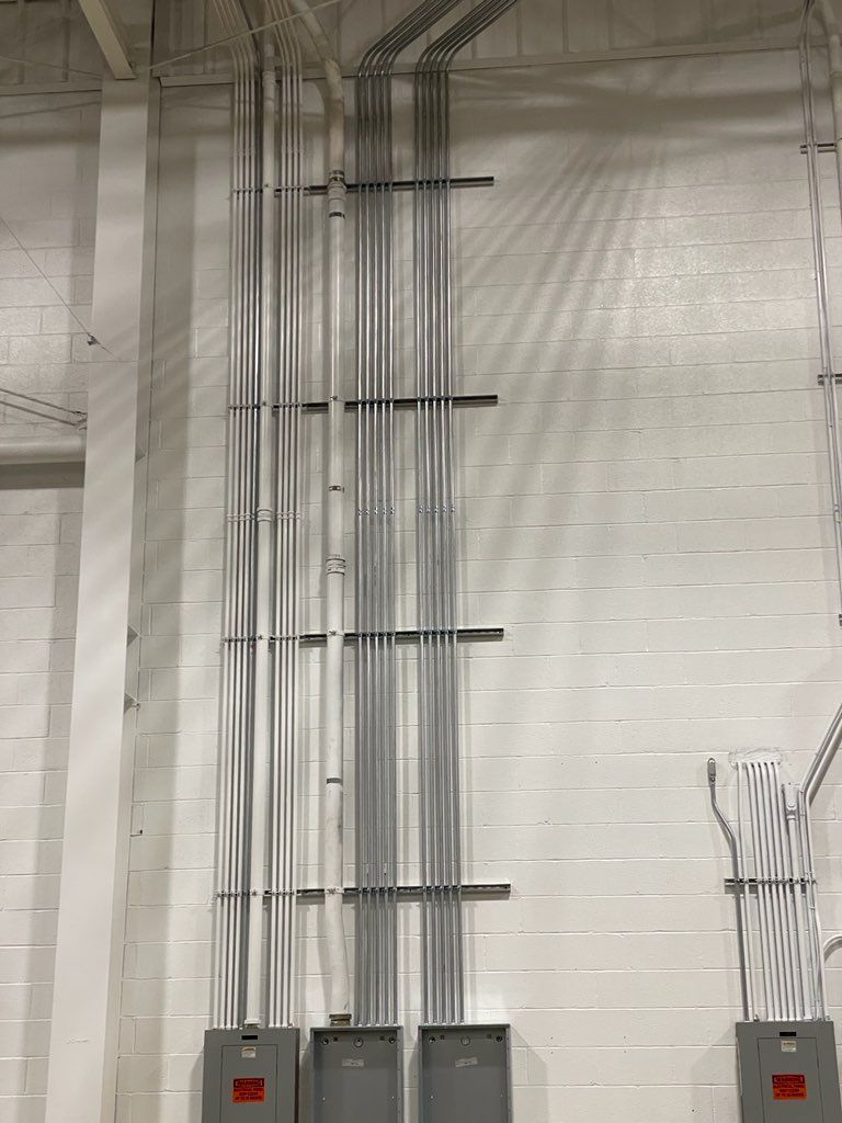 There are a lot of wires hanging from the ceiling of a building.