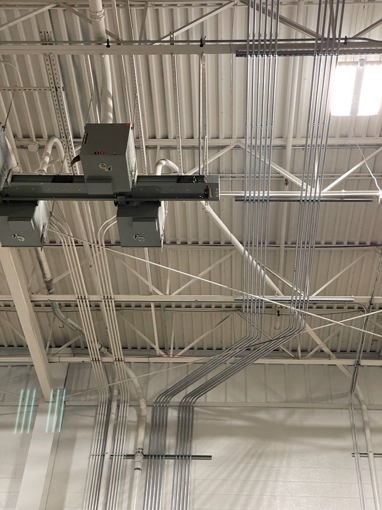 The ceiling of a building with a lot of wires hanging from it.