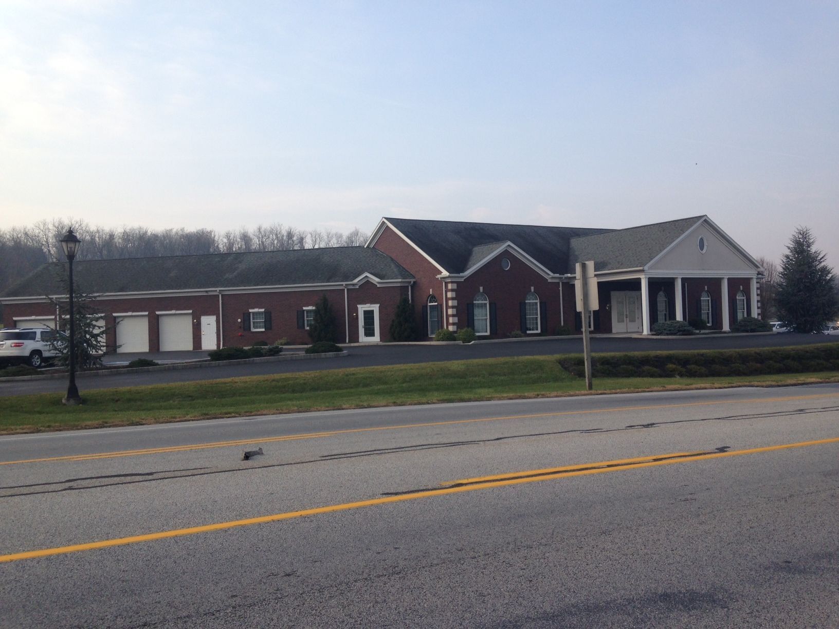 A large brick building sits on the side of a road