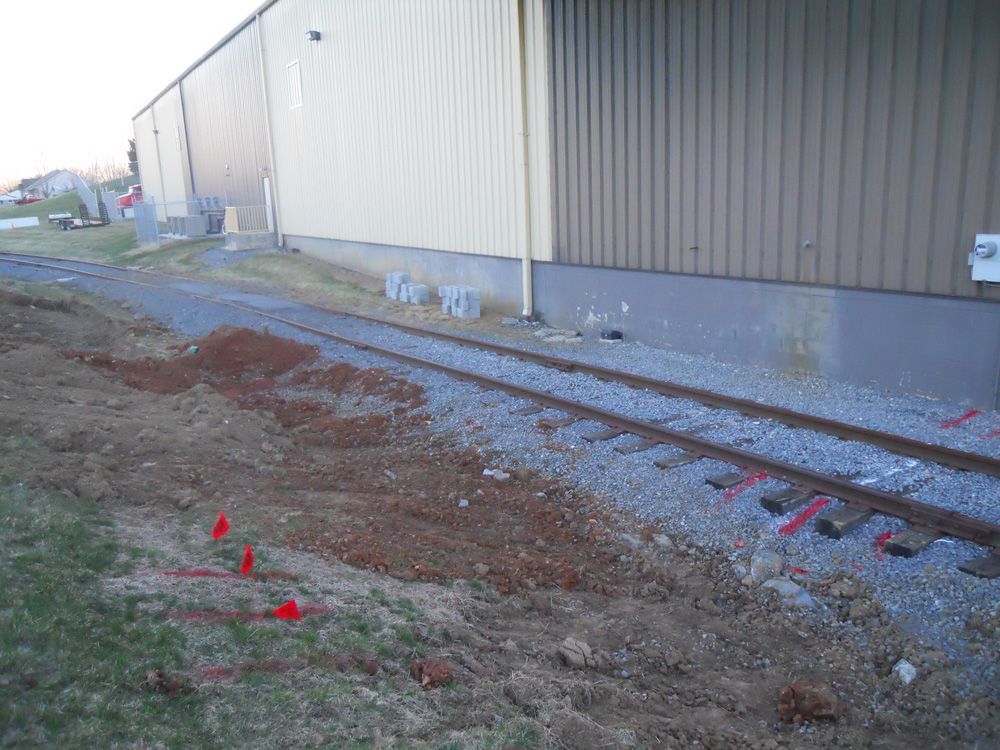 A train track next to a building with red markers on it