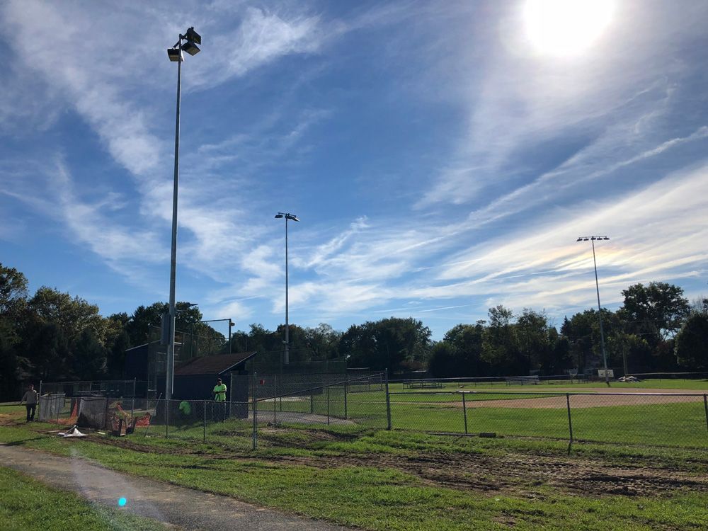 A baseball field with the sun shining through the clouds