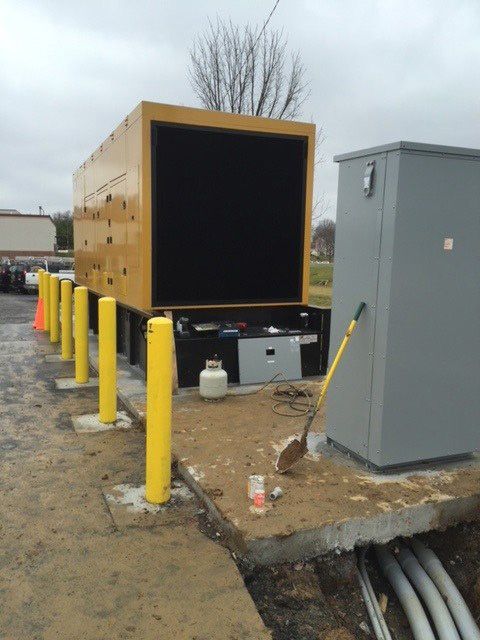A yellow truck is parked next to a gray box