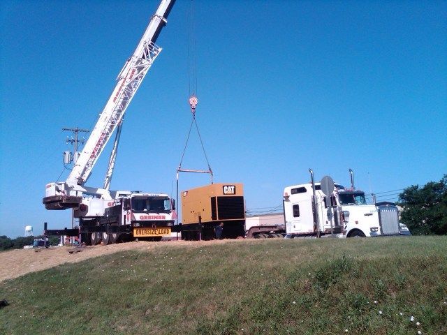 A cat truck is being lifted by a crane