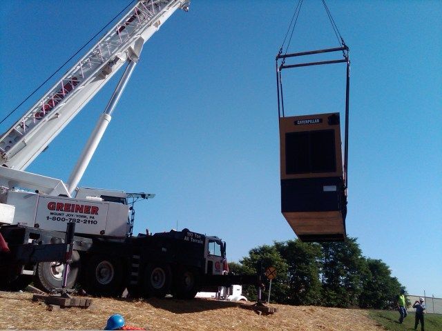A gruner crane is lifting a box into the air
