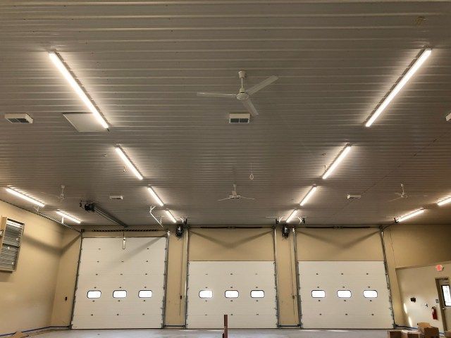 A ceiling fan is hanging from the ceiling of a garage.