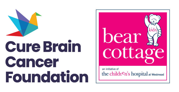 A baby is laying on a bed next to a bear cottage logo
