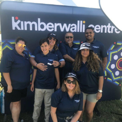 A group of people standing in front of a sign that says kimberwalli centre