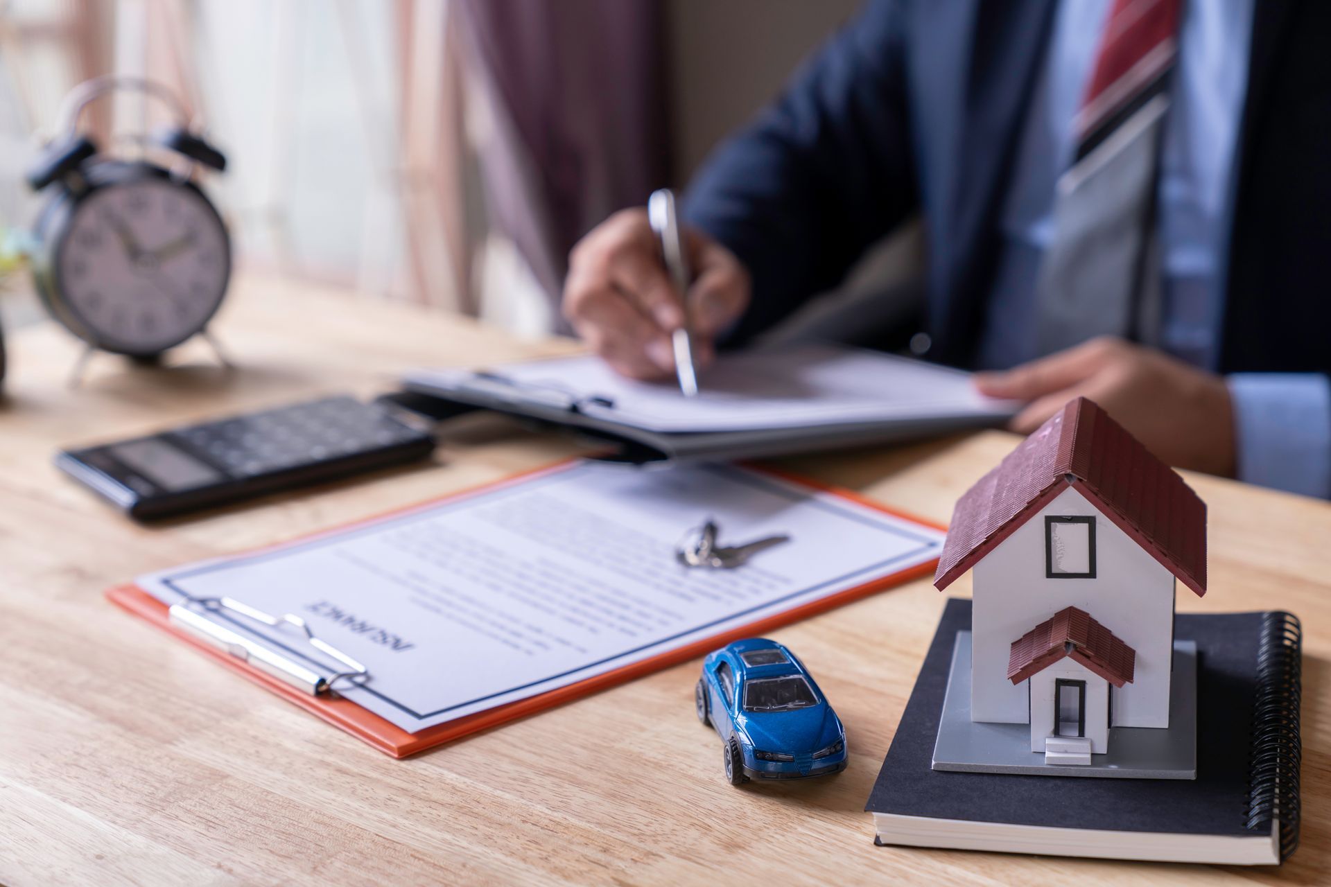 Man signing a contract when buying a new house and car Purchase agreement for ours with model home, Man sign a home insurance policy on home loans, Businessman signing contract insurance.