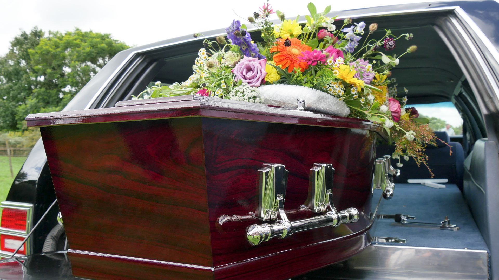 closeup shot of a colorful casket in a hearse or chapel before funeral or burial at cemetery.