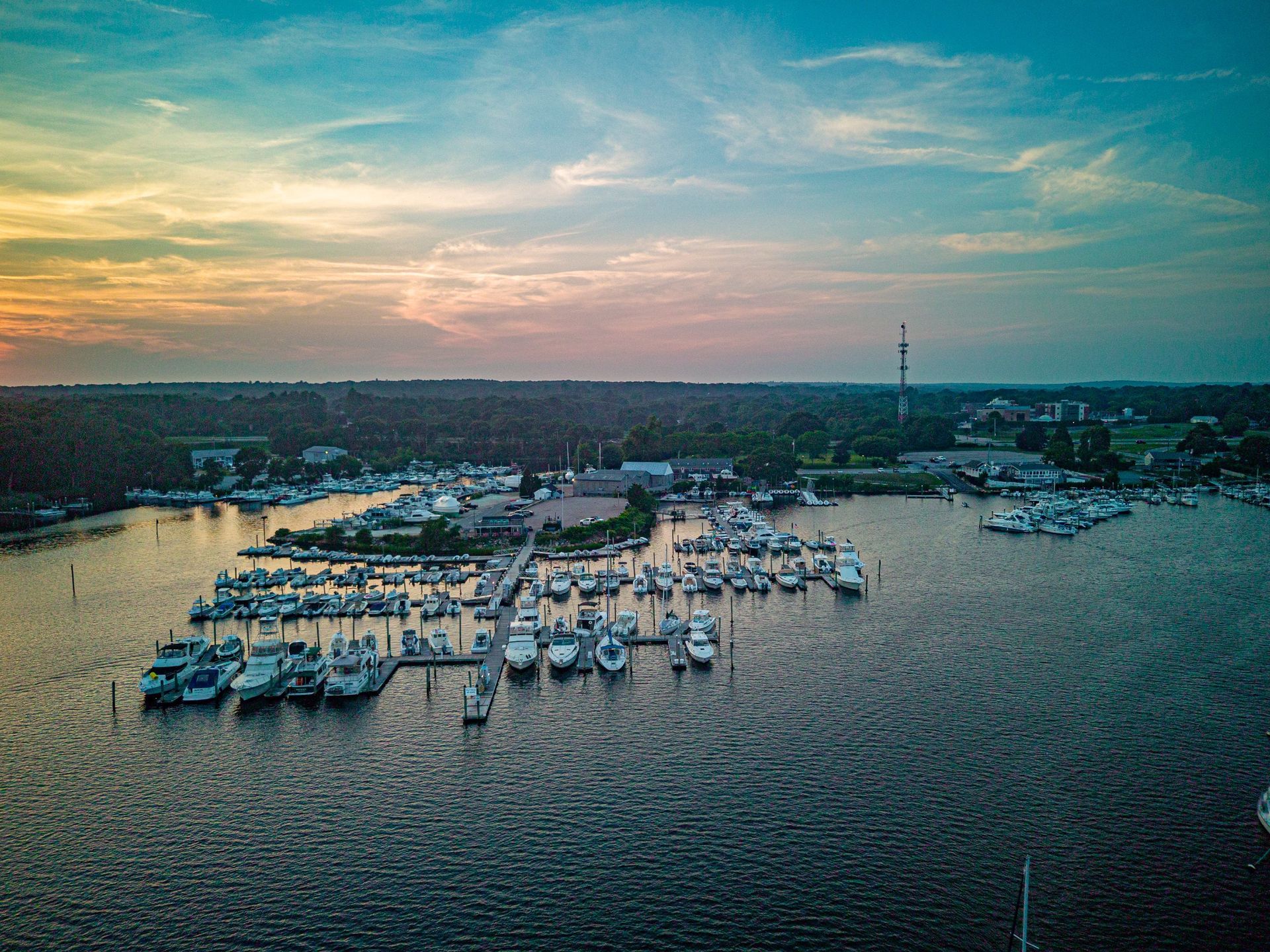 An aerial view of a marina with boats docked at sunset.