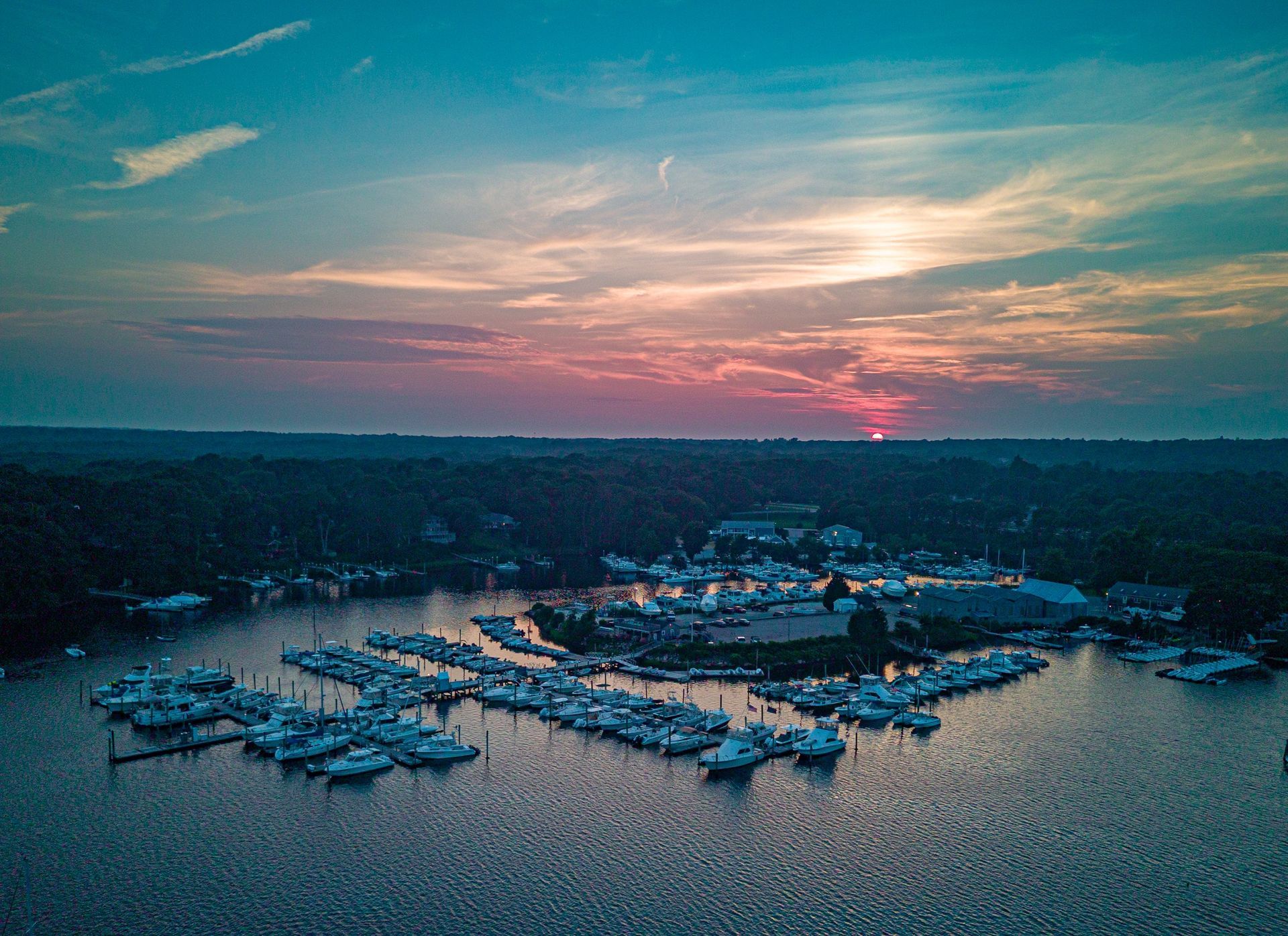 An aerial view of a marina with boats docked at sunset.