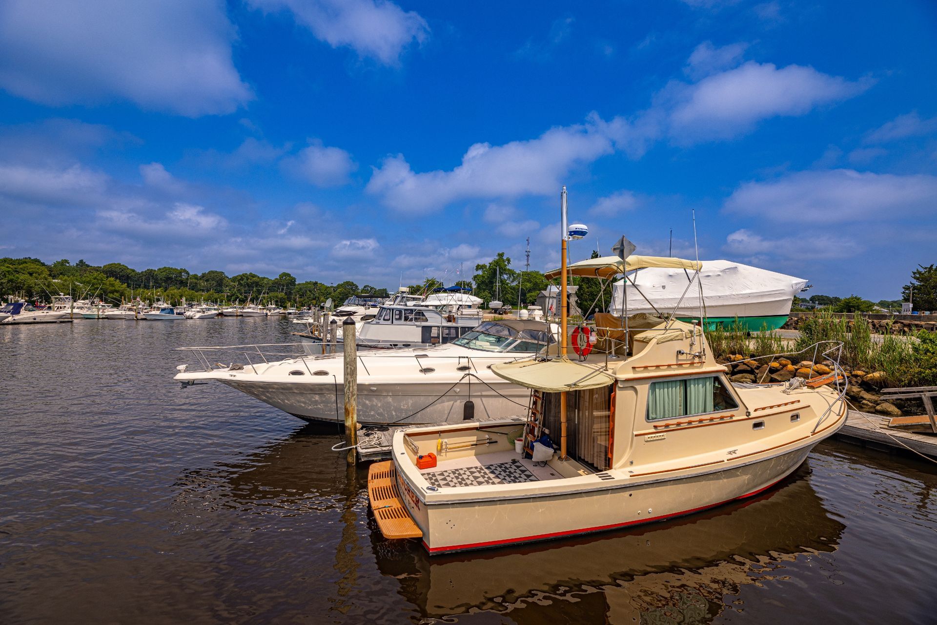 A boat is docked in a marina next to another boat.
