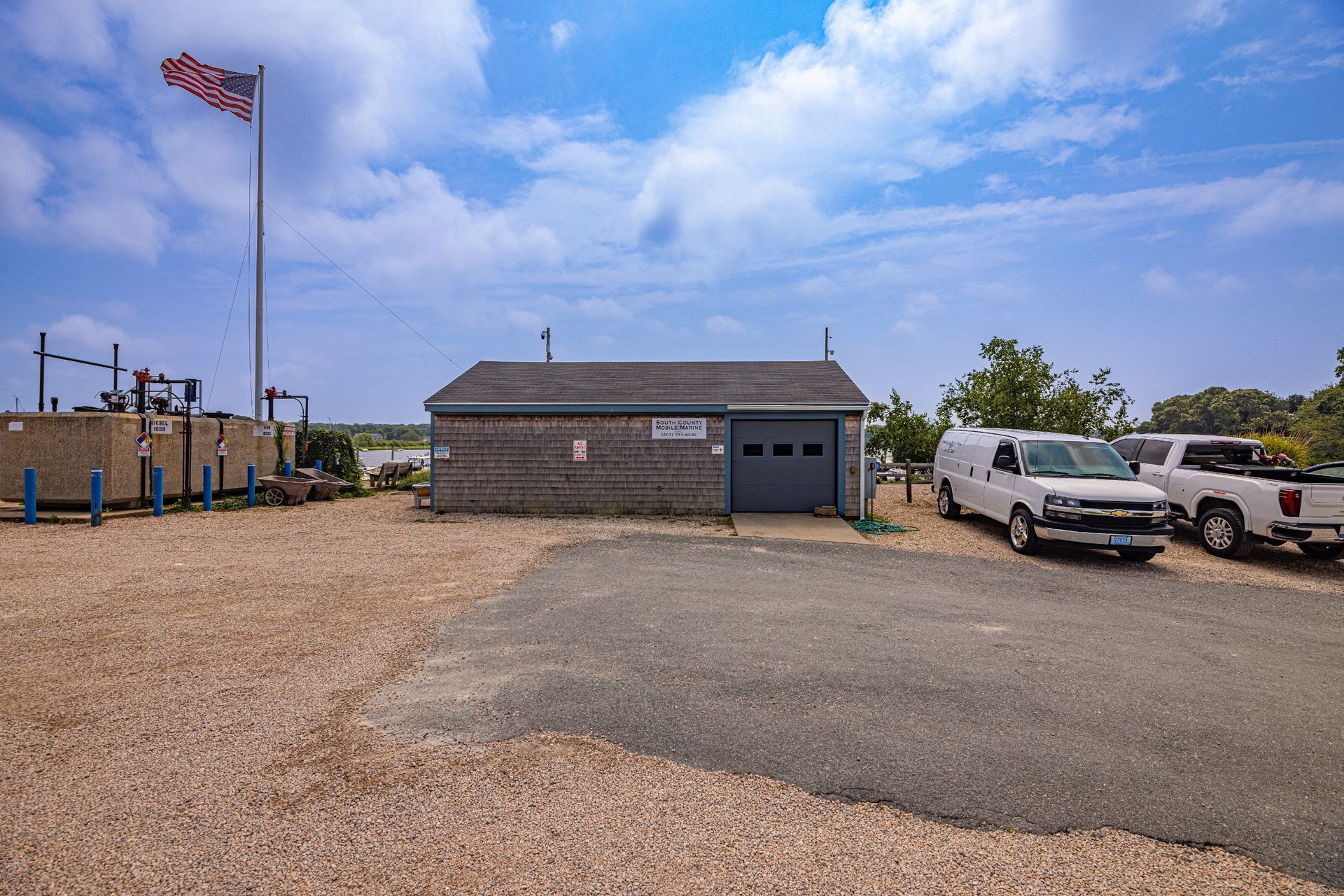 A row of trucks are parked in front of a small building.