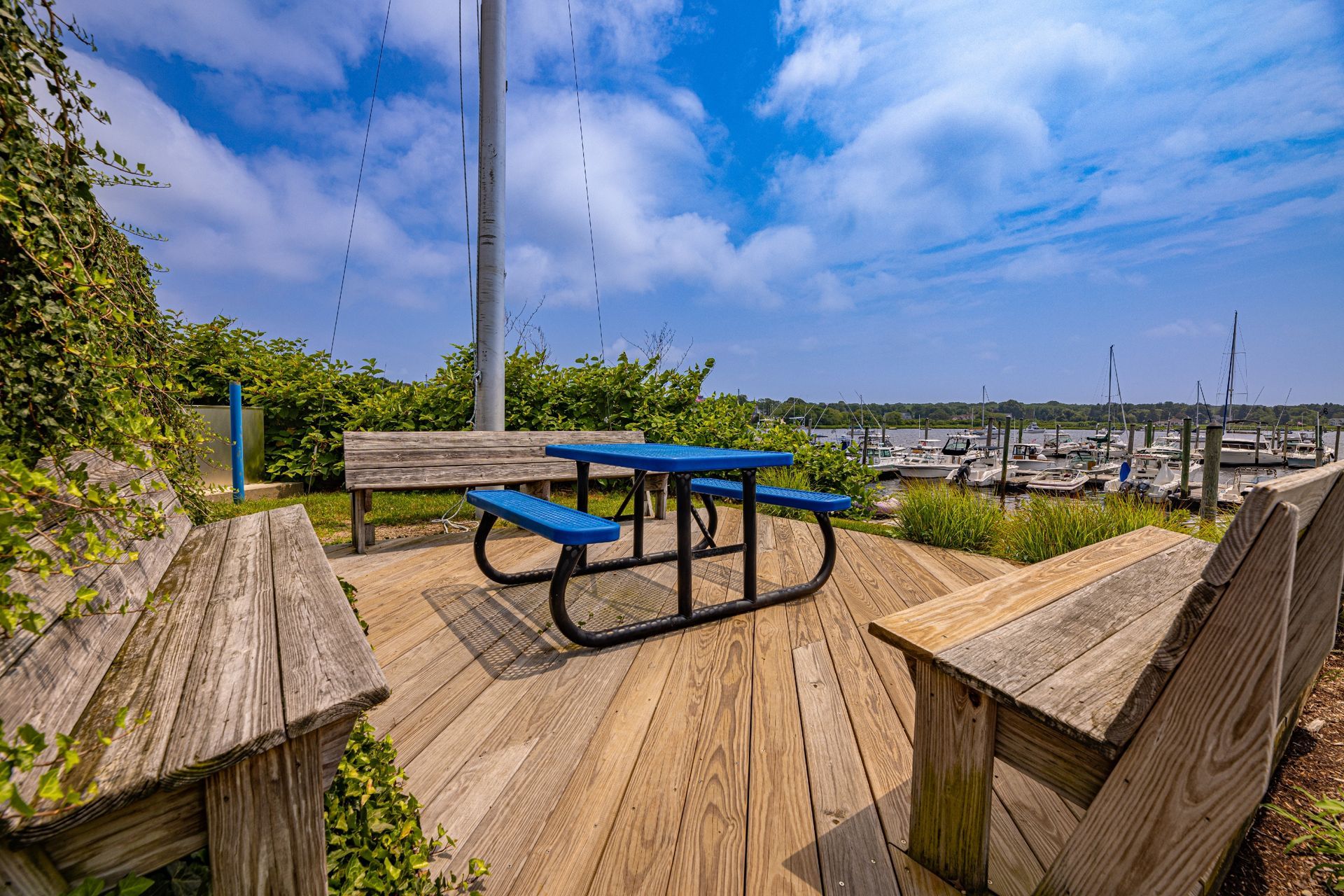 A wooden deck with a blue picnic table and benches.