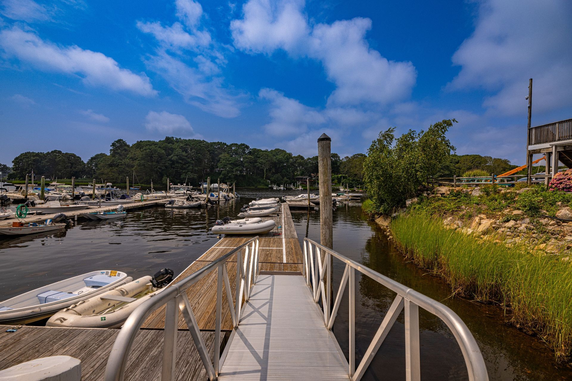 A dock with boats docked at a marina on a sunny day.
