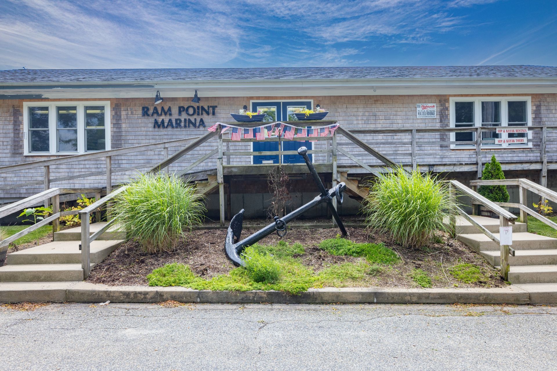 A large anchor is in front of a building that says ram point marina.