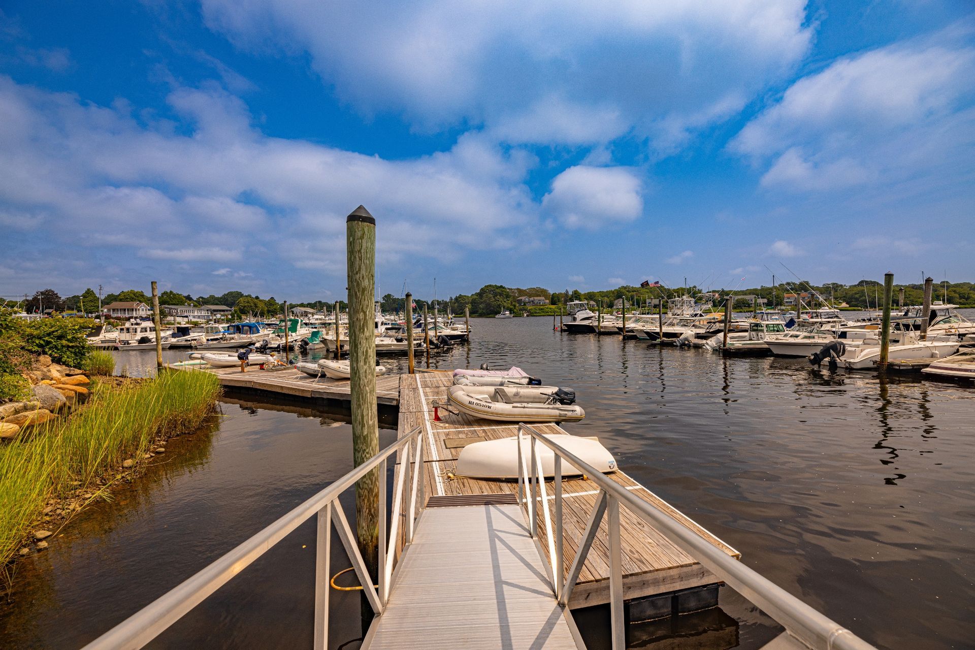 A dock with boats docked at a marina on a sunny day.