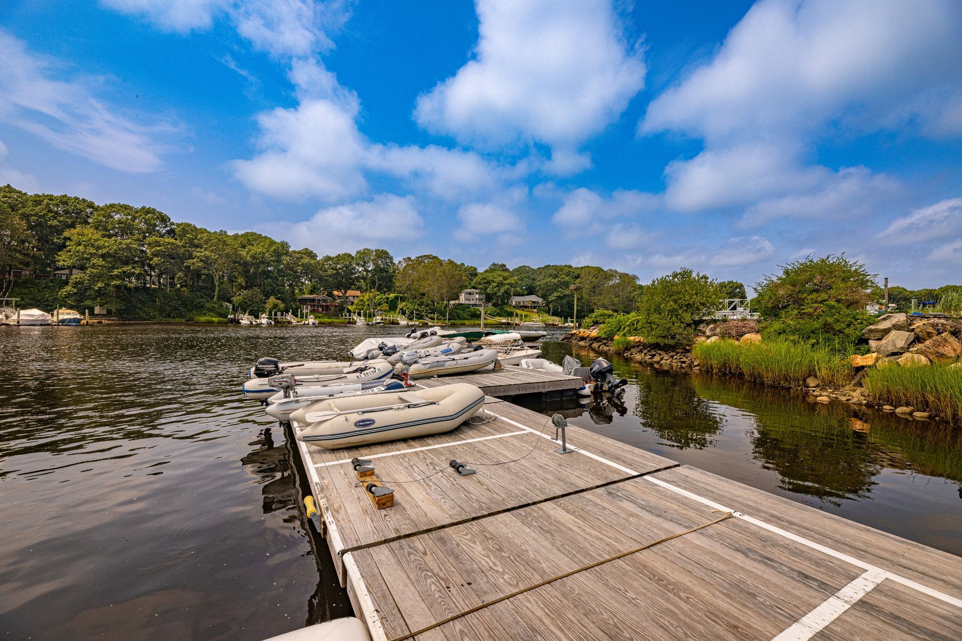 A dock with boats docked in the water on a sunny day.