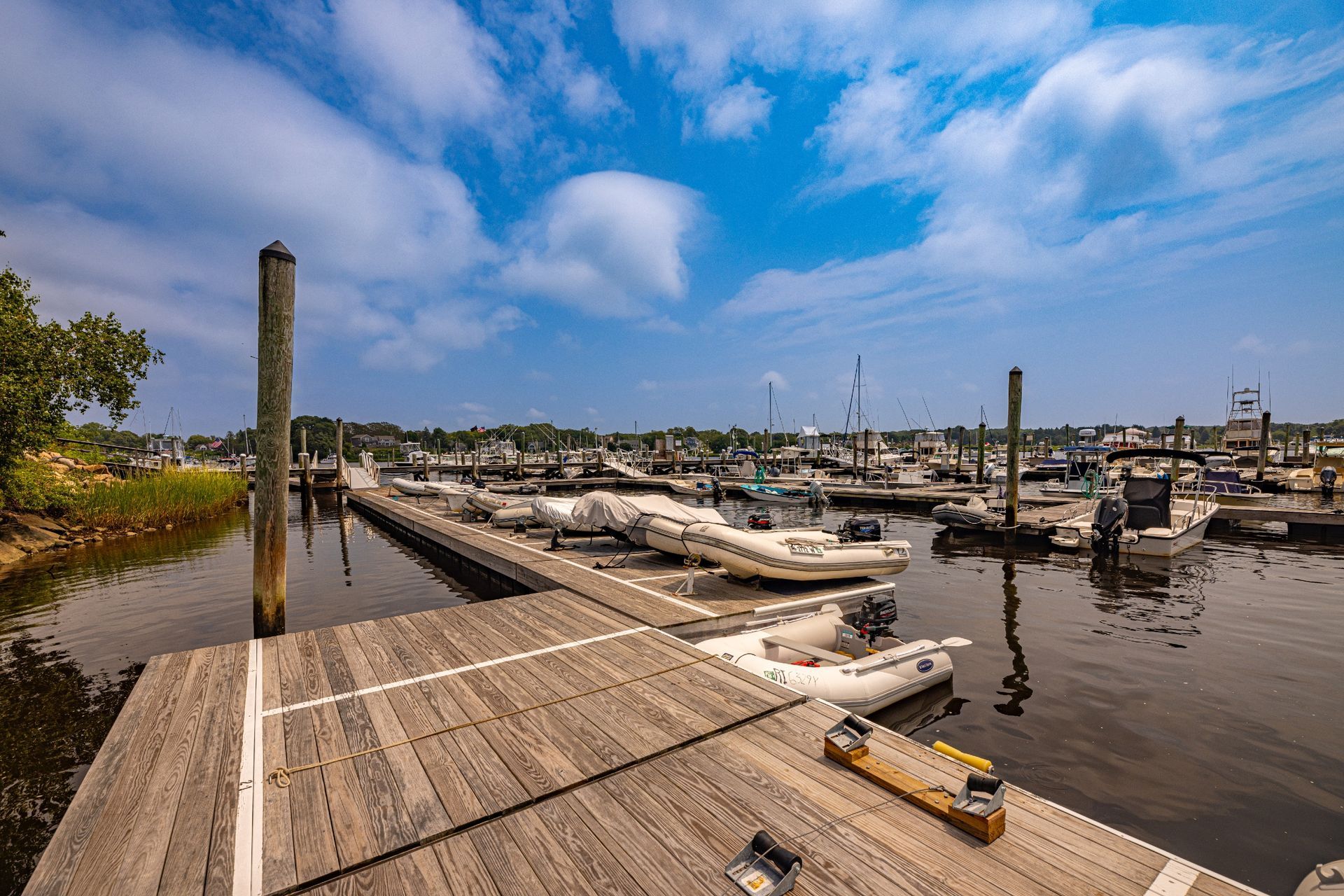 A dock with boats docked in a marina on a sunny day.