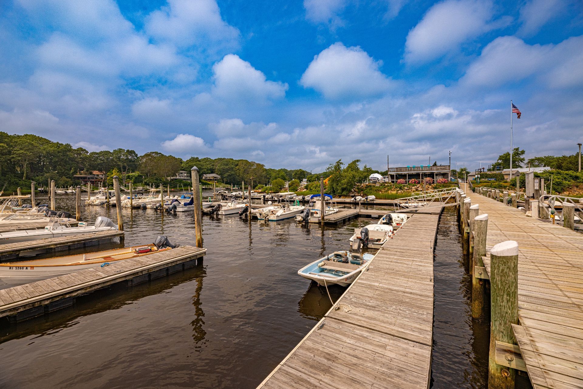 A dock with boats docked at a marina on a sunny day.